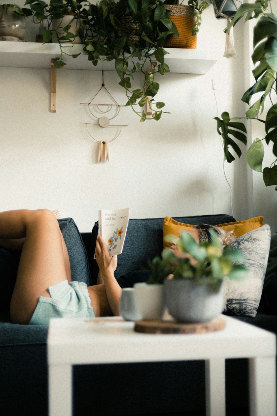 Person leser en bok i sofaen hjemme