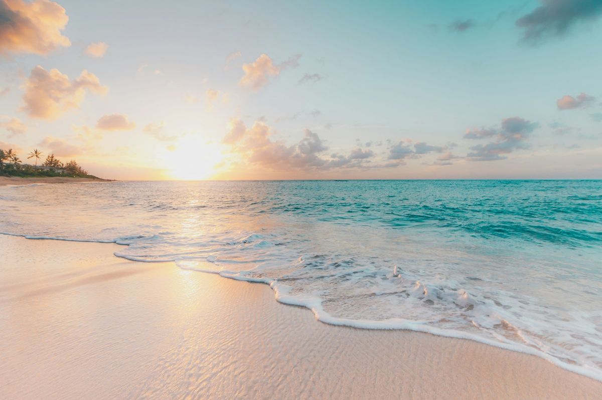 Rolig strand i gyllen ettermiddagslys