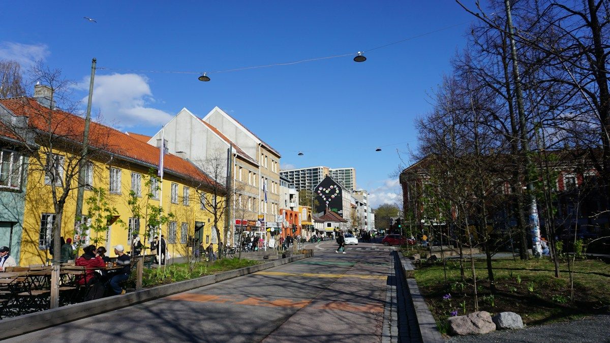 Bygate med trær og boligblokker på Grønland i Oslo som illustrasjon på det norske velferdssamfunnet