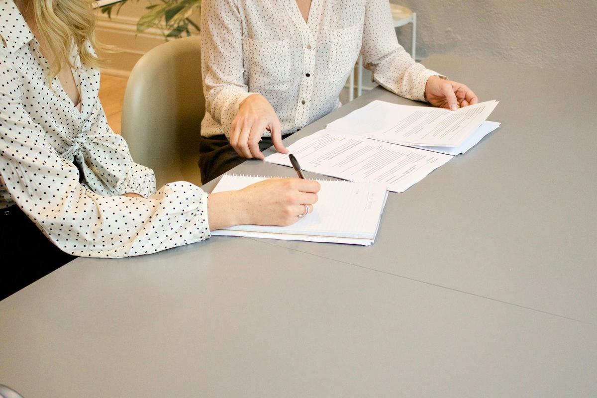 To personer går gjennom papirer sammen ved et bord